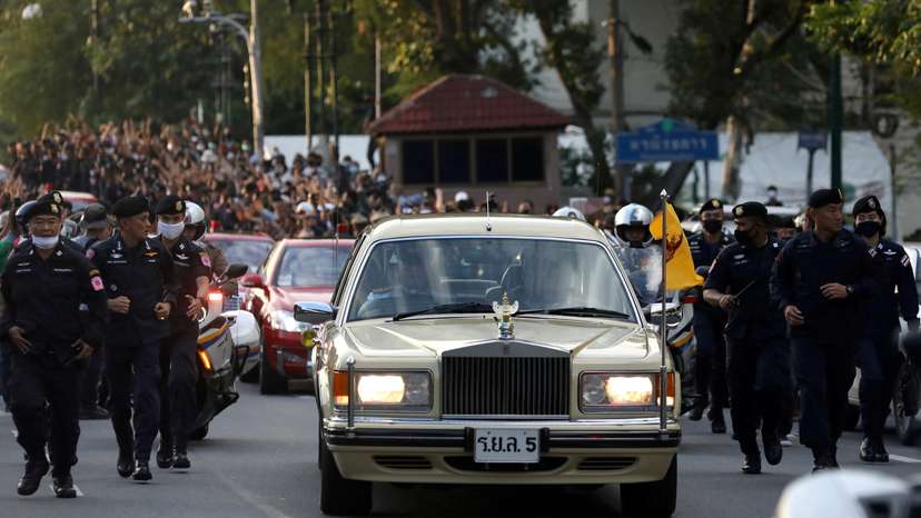 FILE PHOTO: The royal motorcade carrying Thailand's Queen Suthida and Prince Dipangkorn drives past a group of anti-government demonstrators in front of Government House in Bangkok