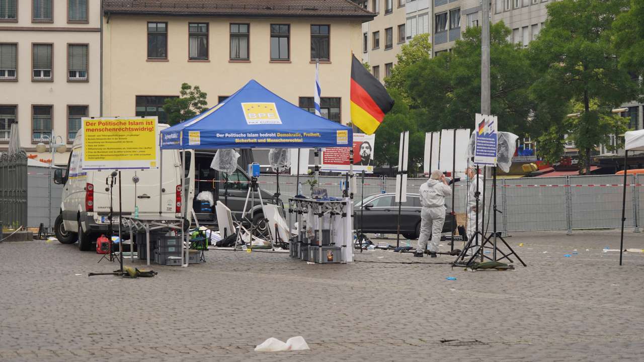 Police investigators work at the scene where a man attacked people in the central market of the city of Mannheim