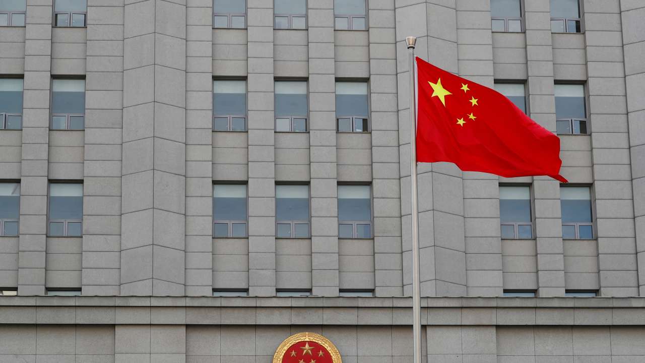 FILE PHOTO: A Chinese national flag waves outside Beijing No. 2 Intermediate People's Court where Australian writer Yang Hengjun is expected to face trial on espionage charges, in Beijing