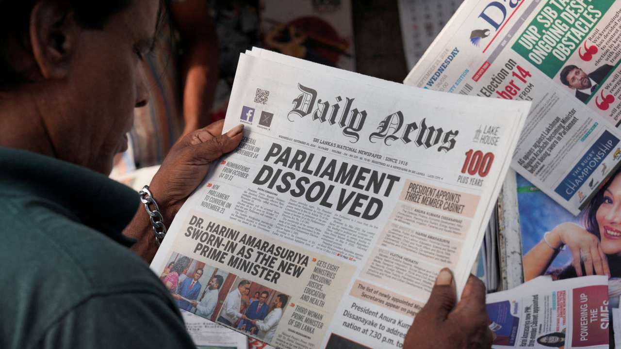 A person reads a newspaper following the appointment of Harini Amarasuriya as the new Prime Minister of Sri Lanka at a stall in Colombo