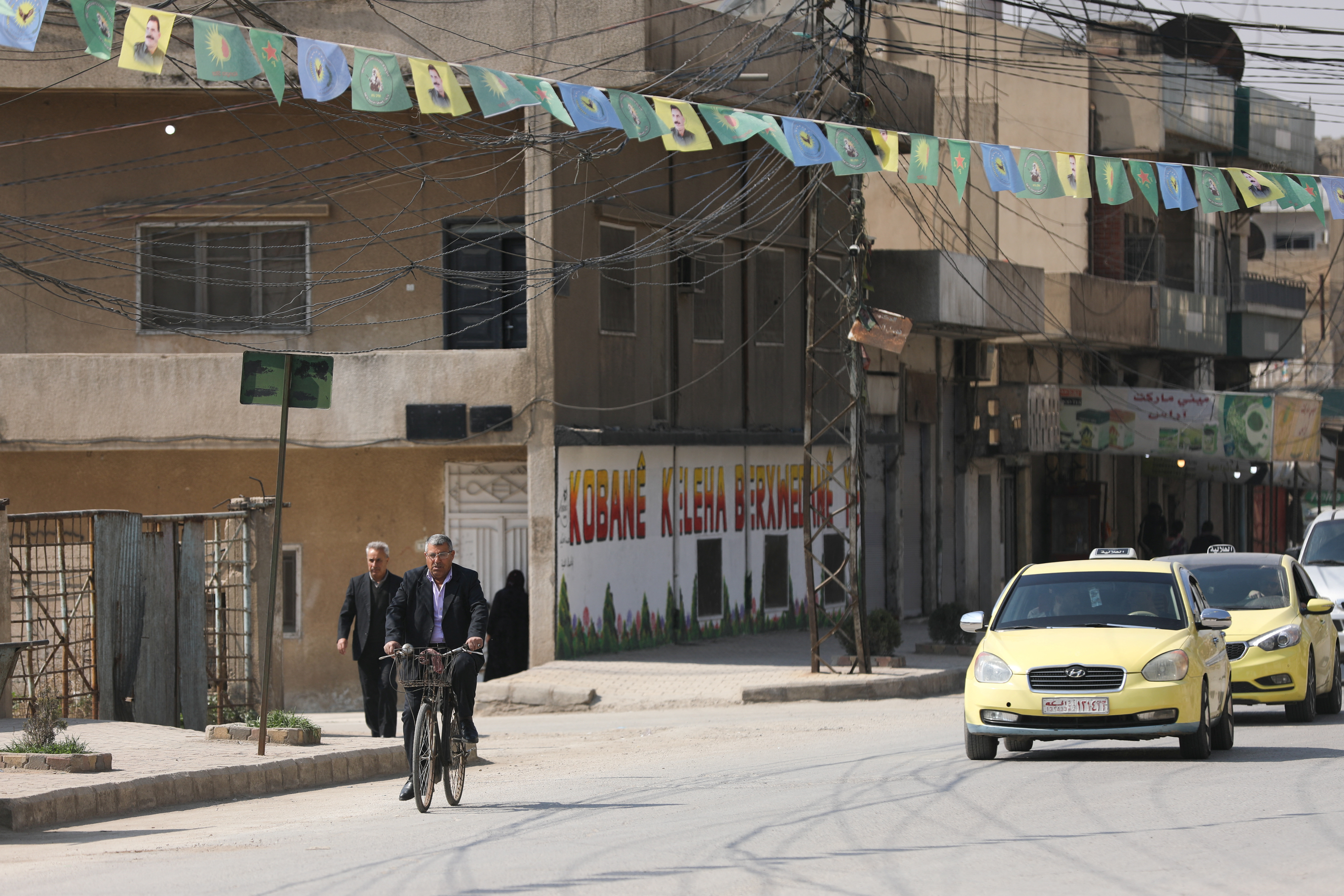A man rides a bicycle, after Syrian Democratic Forces (SDF) signed a deal agreeing to integrate into Syria's new state institutions, in Qamishli