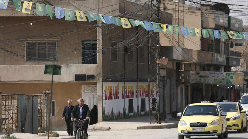 A man rides a bicycle, after Syrian Democratic Forces (SDF) signed a deal agreeing to integrate into Syria's new state institutions, in Qamishli