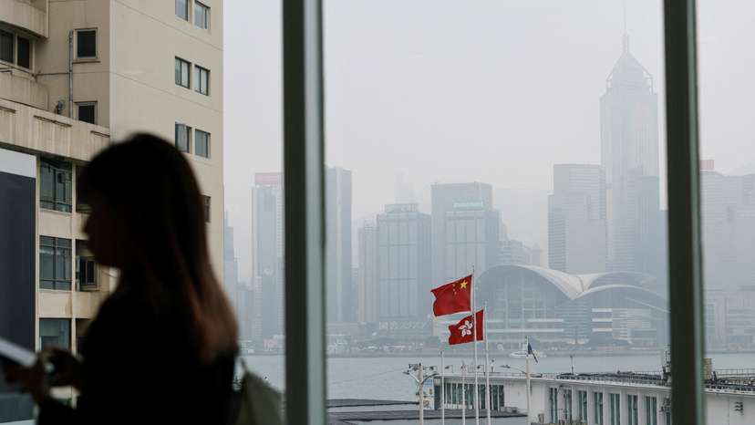 Chinese and Hong Kong flags are seen at the waterfront during a foggy day in Hong Kong